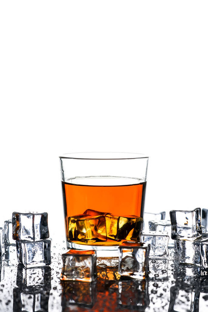 Glass of whiskey and ice cubes.Isolated shot of whiskey.Glass of scotch and ice cubes on a white background. - Photo, Image