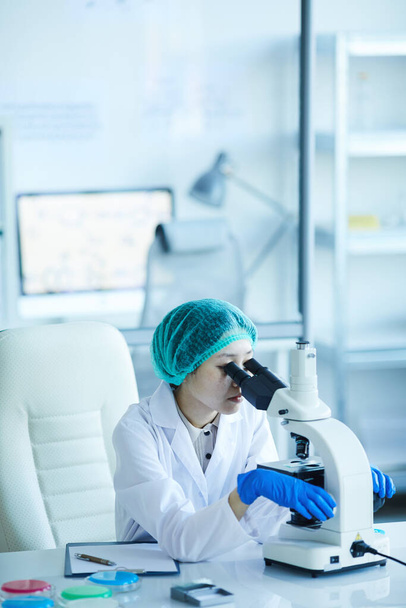 Женщина, анализирующая под микроскопом
 - Фото, изображение