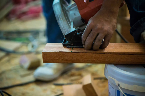 carpenter cutting wood with wooden board - Fotó, kép
