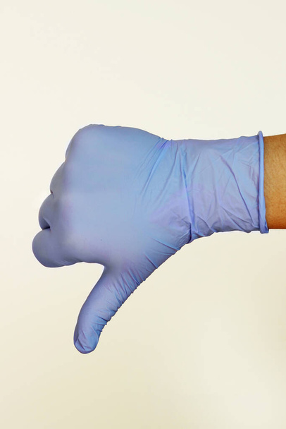 рука в рукавичці великі пальці вниз
 - Фото, зображення
