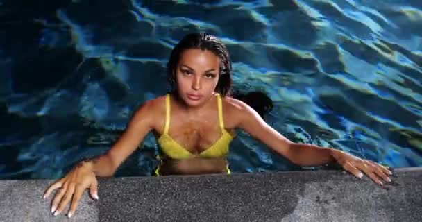Σέξι γυναίκα στην πισίνα τη νύχτα φορώντας κίτρινο μπικίνι - Πλάνα, βίντεο