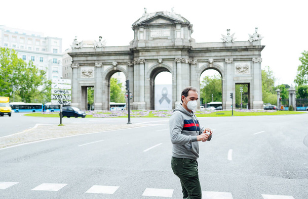 Homme marchant à travers la ville de Madrid avec masque
 - Photo, image