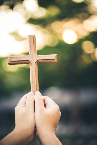 hand holding wooden cross on blurred background - Foto, Imagem