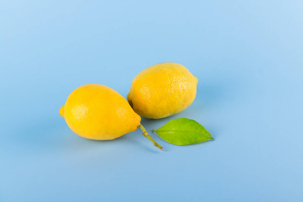 Deux citrons jaunes frais sur fond pastel bleu, protection contre le coronavirus, virus et infections, concept de protection immunitaire minimale, espace pour le texte
 - Photo, image