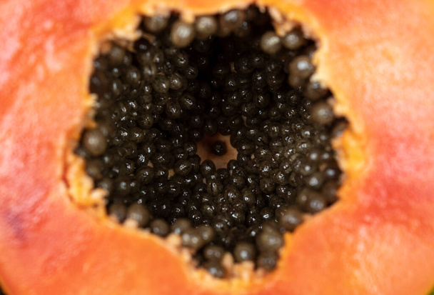 内部の種とオレンジの新鮮なパパイヤを要請するマクロ写真。果物と食感のコンセプト  - 写真・画像