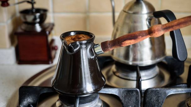 Kaffeezubereitung in dzhezva auf einem Gasherd, selektiver Fokus. - Foto, Bild