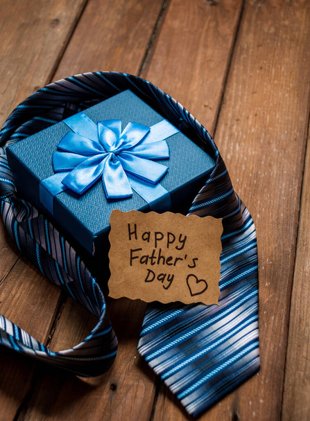 Happy Fathers Day gift box with tie on a rustic wood background. Space for text. - Foto, imagen