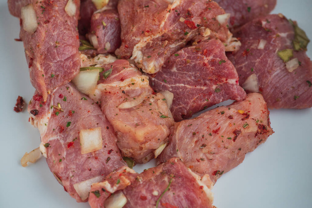 Kebab - morceaux de porc et d'oignon haché, en gros plan photographié. Porc haché en morceaux sur un barbecue aux oignons. Porc cru aux épices, viande marinée. Préparation pour la préparation des plats à base de viande
 - Photo, image