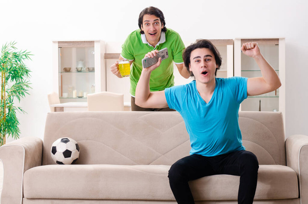 Friends watching football at home - 写真・画像