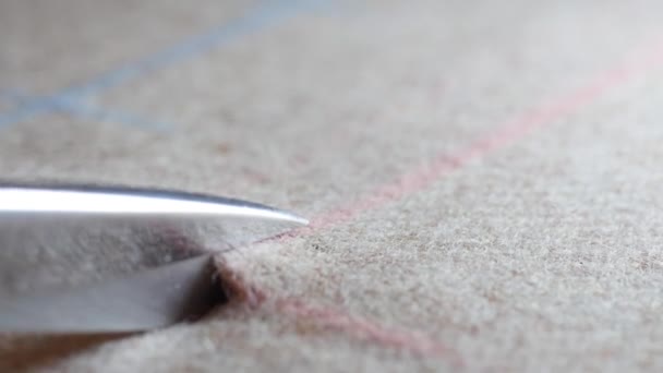 op maat gesneden tweed wol textiel langs krijt zeeplijnen op patroon snijden. Bovenaanzicht van de kleermaker handen werken met een schaar en pak textiel doek. maatwerk kwaliteit Maatwerk van pak Modeontwerper - Video