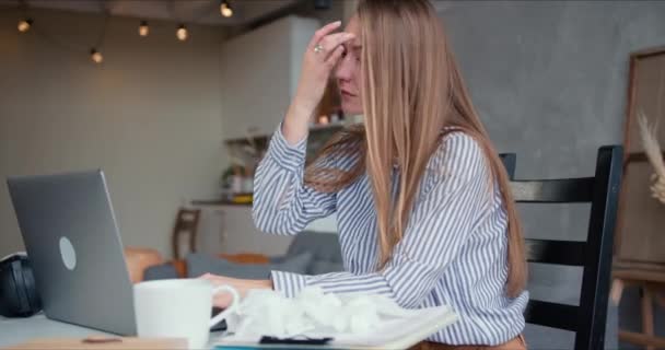 Beautiful young blonde woman using laptop to work, consult people online from home feeling sick on self isolation. - Video