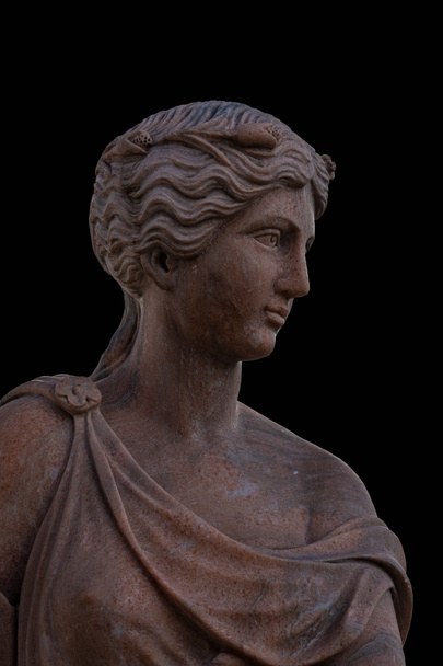 Cabeça de barro de uma deusa grega antiga isolada no fundo preto
 - Foto, Imagem