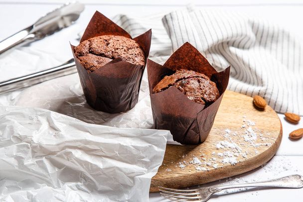 Two chocolate muffins on a wooden cutting board - Фото, зображення