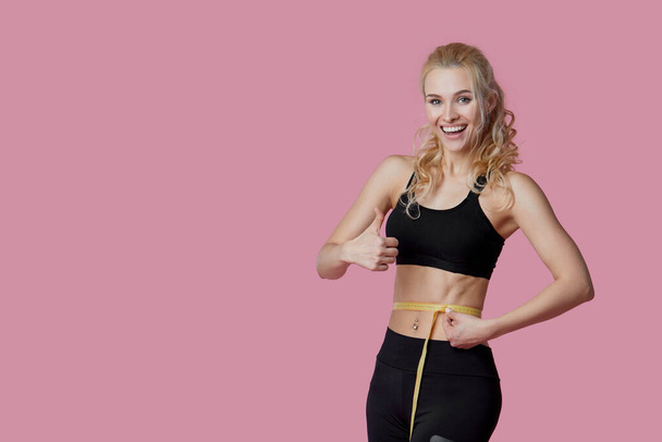 Fitness, workout, healthy lifestyle and diet concept - thin athletes women measure waist after exercise. Quarantine online training - Valokuva, kuva