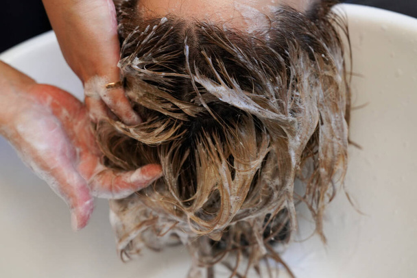 Woman washing hair in salon - Foto, imagen