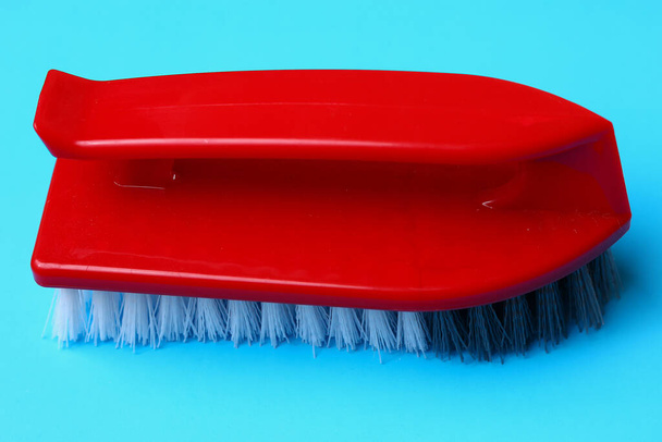 Ручна щітка для чищення та миття на синьому фоні
 - Фото, зображення