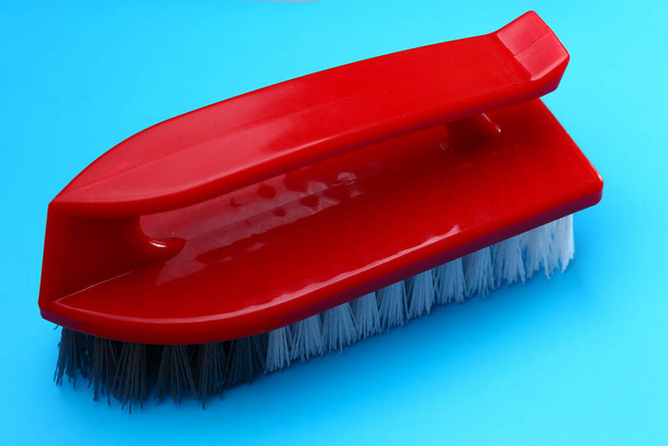 Ручна щітка для чищення та миття на синьому фоні
 - Фото, зображення