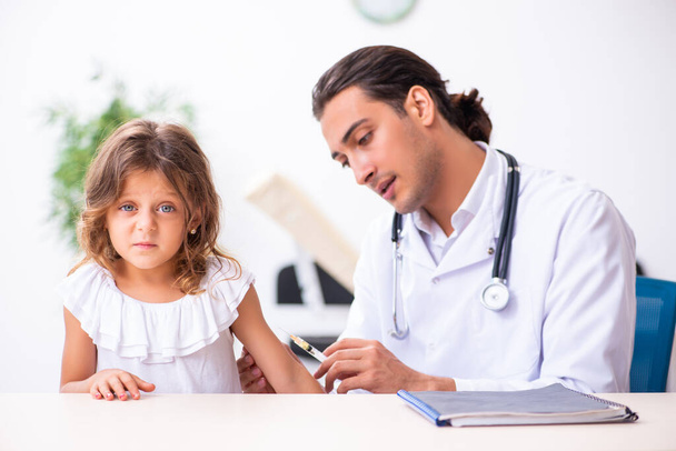 Молодой врач-педиатр с маленькой девочкой
 - Фото, изображение