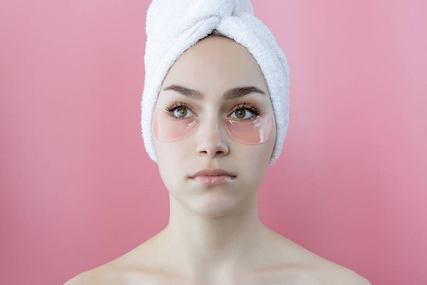 Portrait of Beauty Woman with Eye Patches on pink background. Woman Beauty Face with Mask under Eyes. Skin care, cosmetic product concept. - Photo, Image