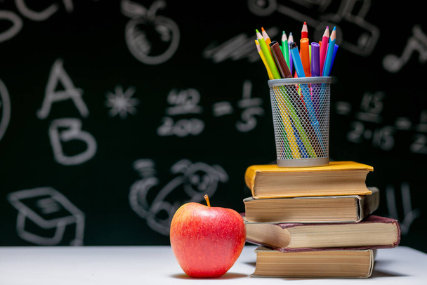 Back to school background with books, pencils and apple on white table - Valokuva, kuva