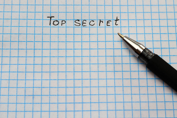 The inscription Top Secret on a sheet of squared notebook, background. - Fotó, kép