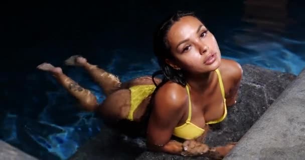 Mulher sexy na piscina à noite usando biquíni amarelo - Filmagem, Vídeo