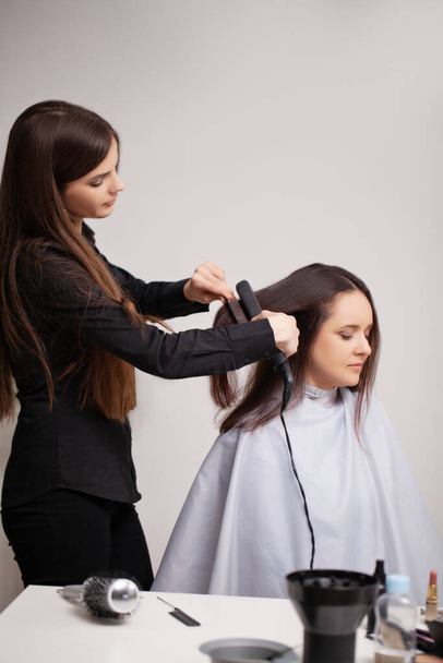 Επαγγελματική κομμώτρια κάνει διαδικασίες περιποίησης μαλλιών στο σπίτι - Φωτογραφία, εικόνα