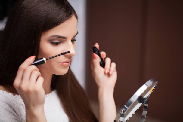 Hezká žena dělá make-up doma před zrcadlem - Fotografie, Obrázek