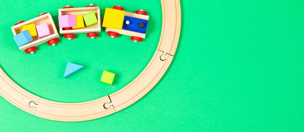 Fa játék vonat színes blokkok és fa vasút világoszöld háttér - Fotó, kép