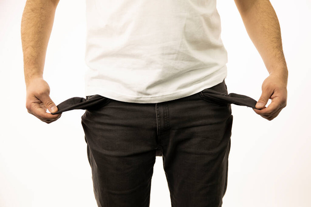 Мужские руки показывают пустые внутренности карманов брюк
 - Фото, изображение