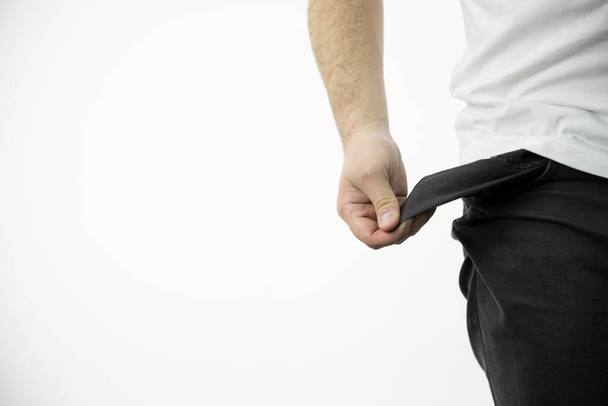 рука чоловіка показує порожню кишеню чорних штанів
 - Фото, зображення