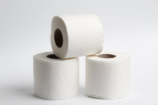 Три рулона туалетной бумаги на светлом фоне
 - Фото, изображение