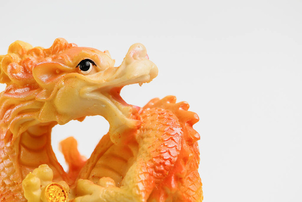 Типичная керамическая фигурка дракона, на светлом фоне
 - Фото, изображение