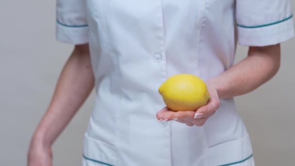 nutricionista médico conceito de estilo de vida saudável - segurando frutas de limão orgânicos e fita métrica
 - Filmagem, Vídeo