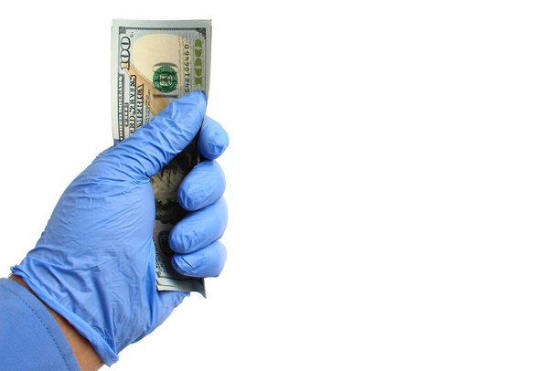 Doctor's hand in a medical glove holds dollars on a white background, isolated. - Photo, Image