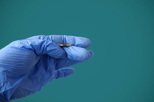 Лікар у медичній рукавичці кидає монету на фон зеленого кольору. Символ вибору - Фото, зображення