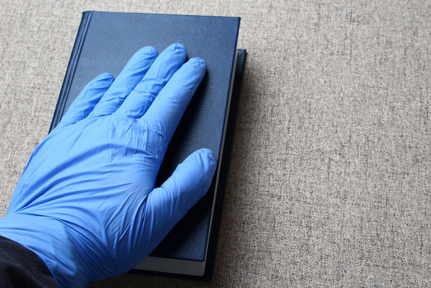 Geef een medische handschoen aan een boek. Hippocratische eed concept - Foto, afbeelding