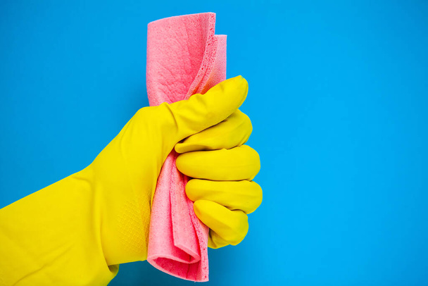 Zbliżenie dłoni w żółtych rękawiczkach zawierających środki czyszczące. - Zdjęcie, obraz