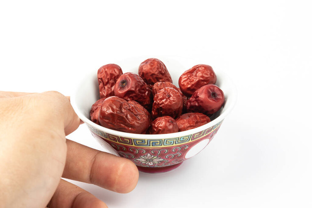 A bowl of Chinese dried red date fruit on white background. - Photo, Image
