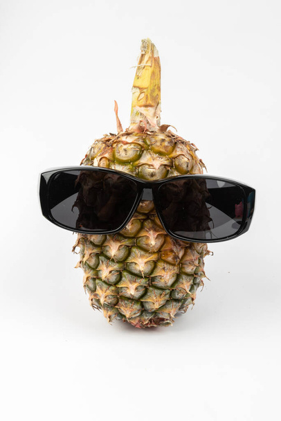 Beyaz arka planda güneş gözlüğü takan ananas. - Fotoğraf, Görsel