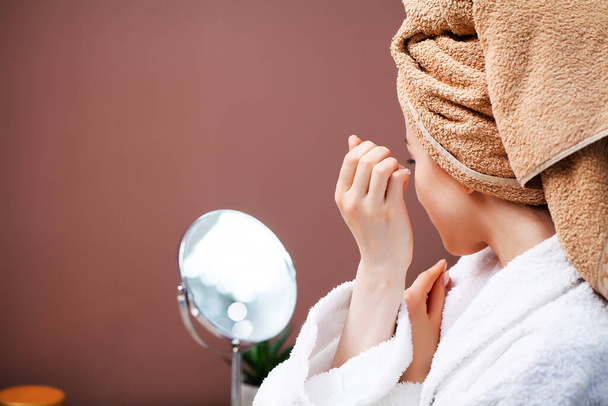 Gros plan femme utilise crème liquide pour prendre soin de la peau du visage
 - Photo, image