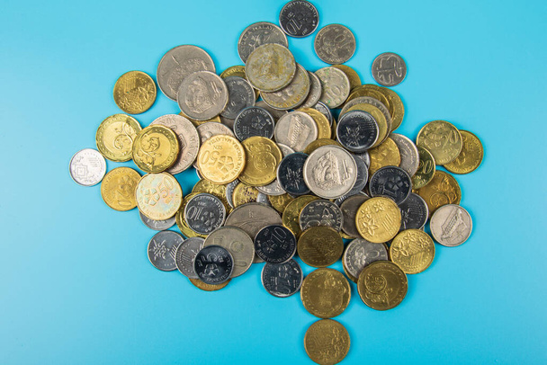 Moeda malaia de moedas malaias em fundo azul. Conceito Financeiro
 - Foto, Imagem