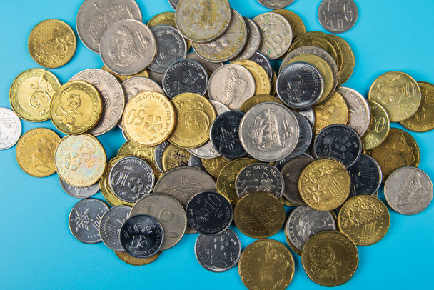Moneda de Malasia de monedas de Malasia sobre fondo azul. Concepto financiero
 - Foto, Imagen