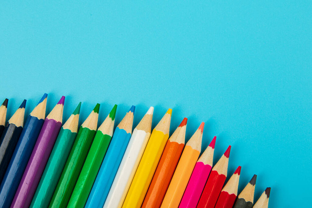 portrait of set of colorful pencils on blue background with copy space - Fotó, kép