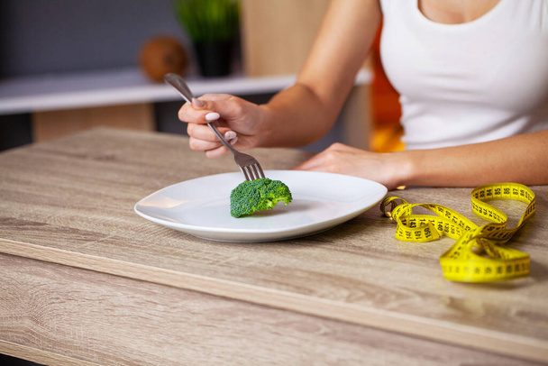 Concetto di donna sovrappeso che mangia broccoli dieta
. - Foto, immagini