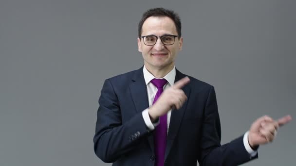 Happy handsome adult businessman pointing with hands to left side, text space - Materiał filmowy, wideo