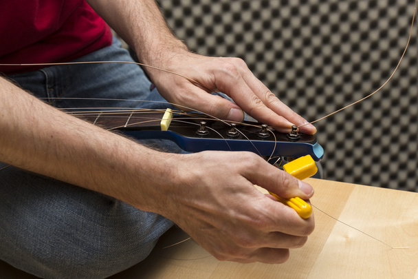 Guitarist using the string winder - Photo, Image