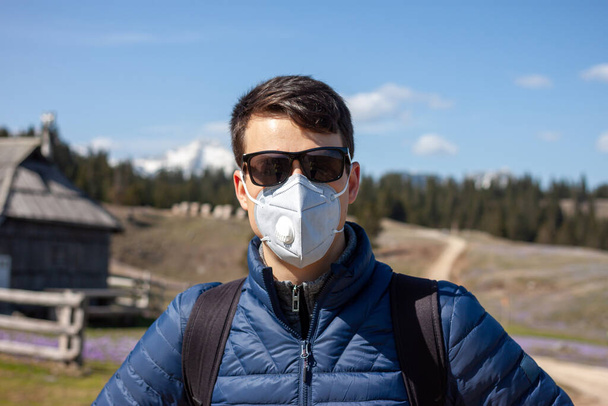 hombre joven con máscara y gafas de sol caminando fuera
 - Foto, imagen
