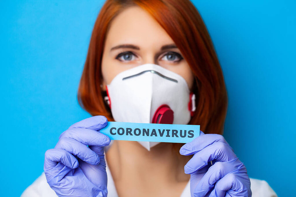 Woman in protective gloves holding inscription coronavirus. - Valokuva, kuva