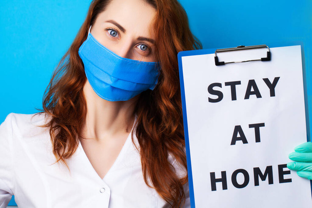 Женщина держит пустой с надписью остаться дома, призывая прекратить распространение covid-19
 - Фото, изображение